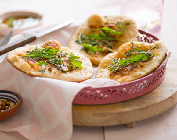 Naan pizza with herbs, pine nuts and rocket