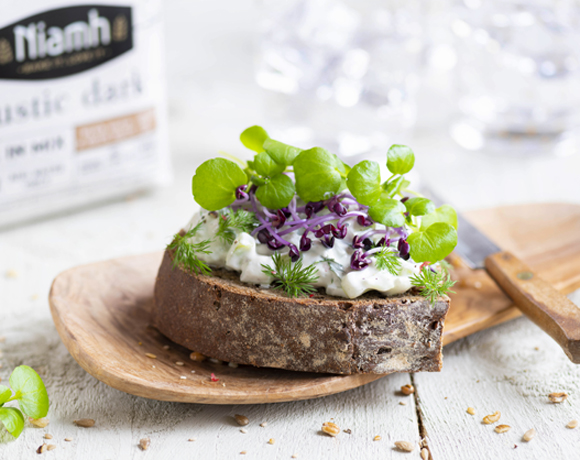 Rustic Dark sandwich with homemade tzatziki, purple or green sprouts, and watercress